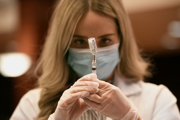 FILE - In this March 3, 2021, file photo, pharmacist Madeline Acquilano draws a syringe of Johnson &amp; Johnson COVID-19 at Hartford Hospital in Hartford, Conn. Despite the clamor to speed up the U.S ...