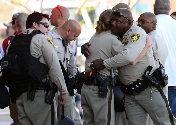 LAS VEGAS, NV - JUNE 08: Las Vegas Metropolitan Police Department officers hug near a Wal-Mart on June 8, 2014 in Las Vegas, Nevada. Two officers were reported shot and killed by two assailants at a pizza restaurant near the Wal-mart. The two suspects then reportedly went into the Wal-Mart where they killed a third person before killing themselves.   Ethan Miller/Getty Images/AFP
== FOR NEWSPAPERS, INTERNET, TELCOS & TELEVISION USE ONLY ==