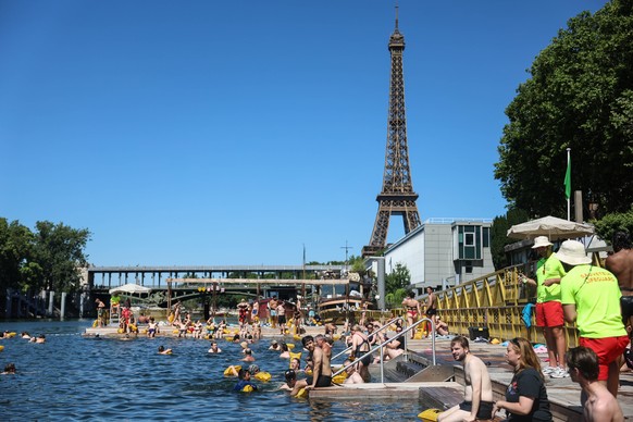 epa13086268 People swim at a designated swimming area on the Seine River in the Bras de Grenelle near the Eiffel Tower in Paris, France, 04 July 2026. Paris Plages 2026 runs from 04 July to 30 August  ...