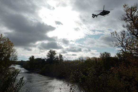 epa08005333 Helicopters fly over the Tarn river as rescuers are at work to recover victims after a suspension bridge collapsed in Mirepoix-sur-Tarn, near Toulouse, southern France, 18 November 2019. A ...