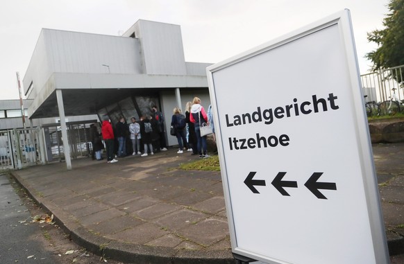 epa09496844 Journalists and spectators queue at the entrance of the premises of the provisional courtroom of the regional court in Itzehoe, northern Germany, 30 September 2021. At juvenile division of ...