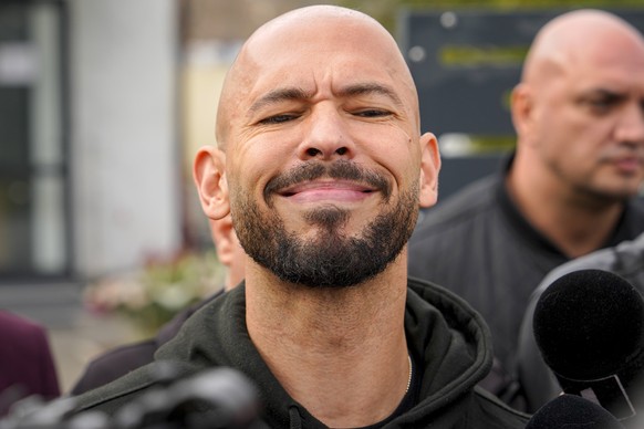 FILE - Andrew Tate reacts while speaking to media after checking in at a police station as part of his judicial control, which requires him to appear before judicial authorities in Romania when summon ...