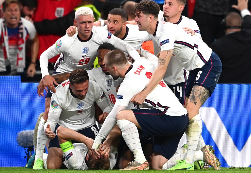epa09330371 Harry Kane (bottom) of England celebrates with teammates after scoring the 2-1 lead from the penalty spot during the UEFA EURO 2020 semi final between England and Denmark in London, Britai ...