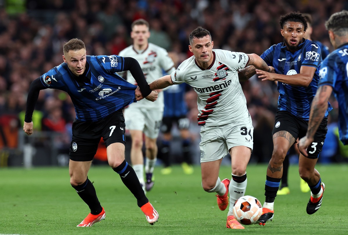 epa11361553 Teun Koopmeiners (L) and Ederson (R) of Atalanta and Granit Xhaka of Leverkusen in action during the UEFA Europa League Final soccer match of Atalanta BC against Bayer 04 Leverkusen, in Du ...