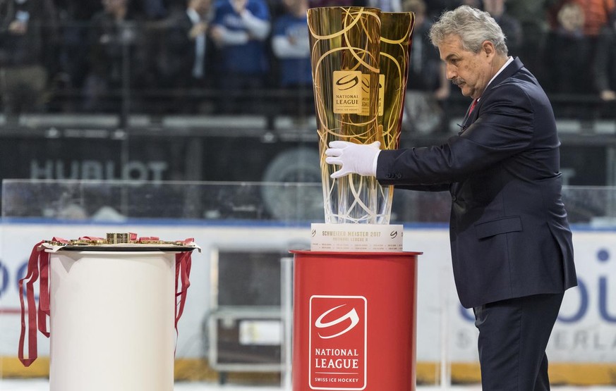 Der Leiter Spielbetrieb der Nationalliga, Willi Voegtlin richtet den Meisterpokal fuer die Siegerehrung nach dem sechsten Eishockey Playoff-Finalspiel der National League A zwischen dem EV Zug und dem ...