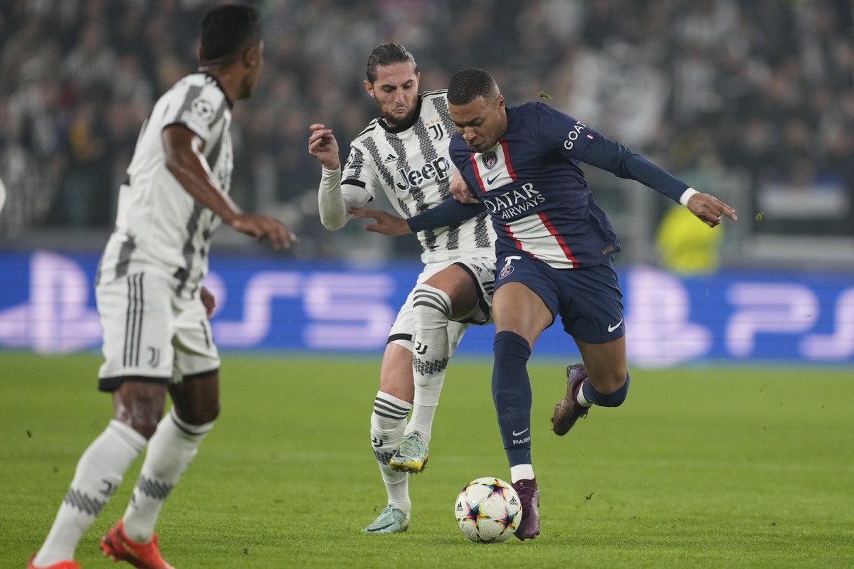 PSG's Kylian Mbappe, right, fights for the ball with Juventus' Adrien Rabiot during the Champions League group H soccer match between Juventus and Paris Saint Germain at the Allianz stadium  ...