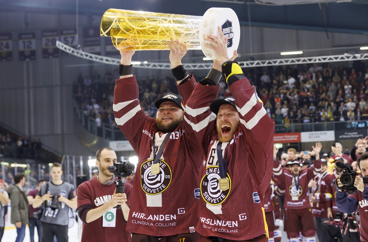 Geneve-Servette's forward Teemu Hartikainen, left, and Geneve-Servette's forward Linus Omark, right, celebrate together with the trophy of Swiss Champion after winning by 4:1 the seventh and ...