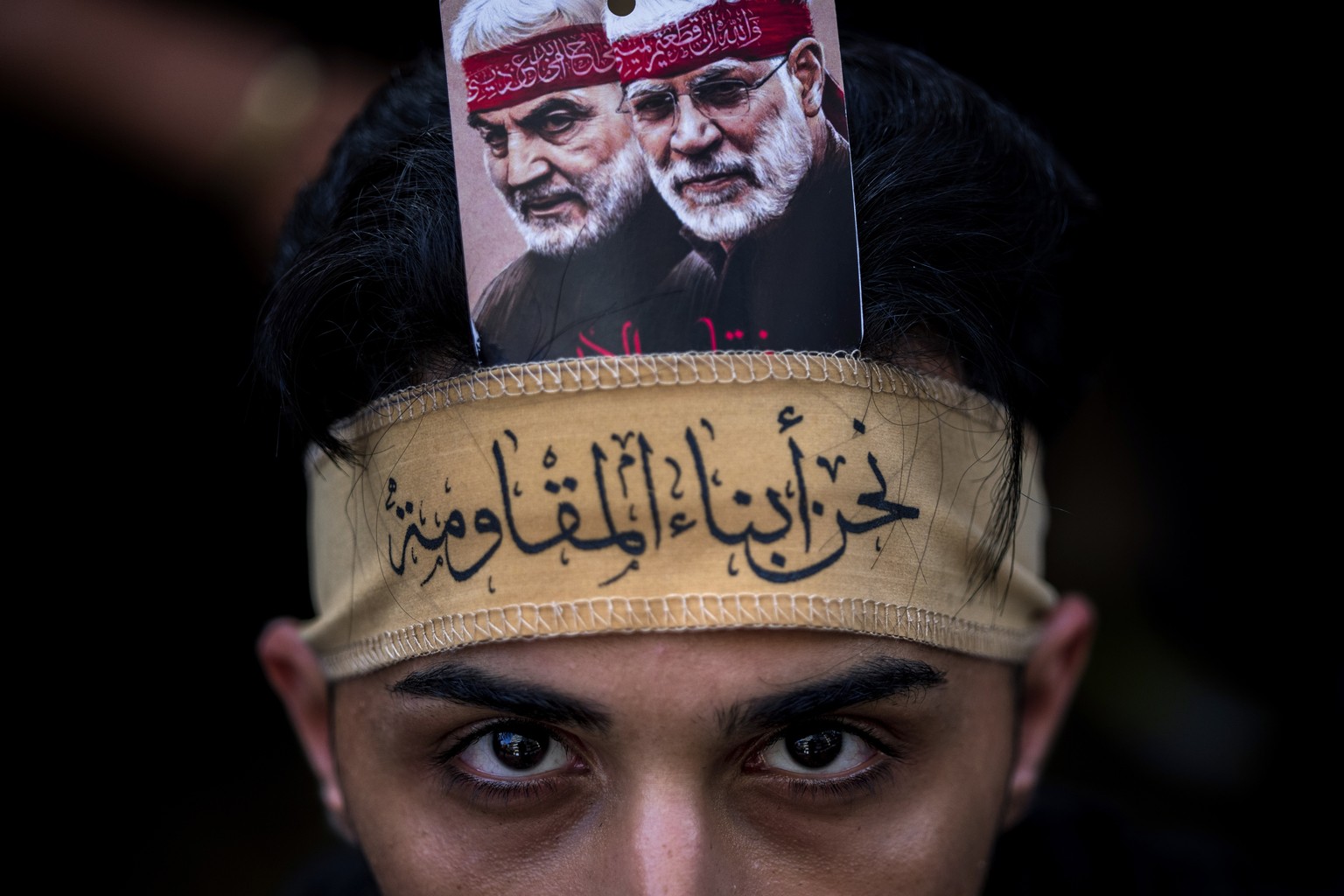 A Hezbollah supporter with portraits of slain Iranian Revolutionary Guard Gen. Qassem Soleimani, left, and slain Iraq&#039;s Popular Mobilization forces commander Abu Mahdi al-Muhandis, poses for a ph ...
