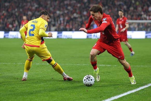 Turkey's Kenan Yildiz, right, vies for the ball with Romania's Andrei Ratiu during the 2026 World Cup playoff semifinal soccer match between Turkey and Romania, in Istanbul, Turkey, Thursday ...