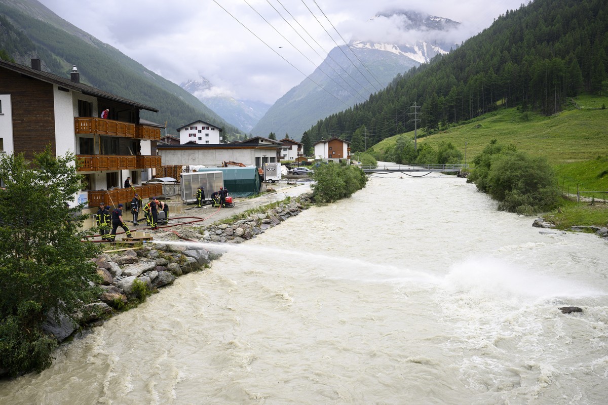 epa11449417 Fire brigade members work near the Saaser Vispa river following storms that caused major flooding in Saas-Grund, Switzerland, 01 July 2024. Severe storms and torrential rain over the weeke ...