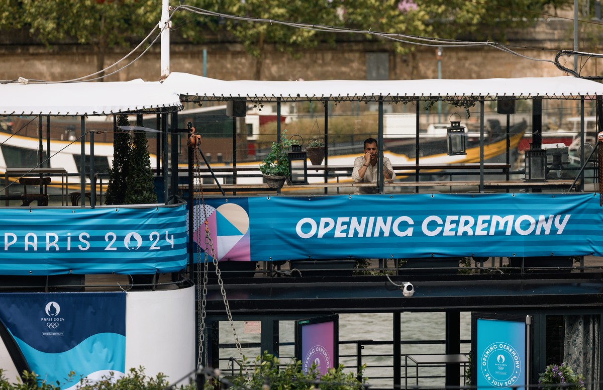 epa11493297 A man stands on a boat on the Seine River amid preparations for the Olympic Opening Ceremony in Paris, France, 23 July 2024. The opening ceremony of the Paris 2024 Olympic Games will begin ...