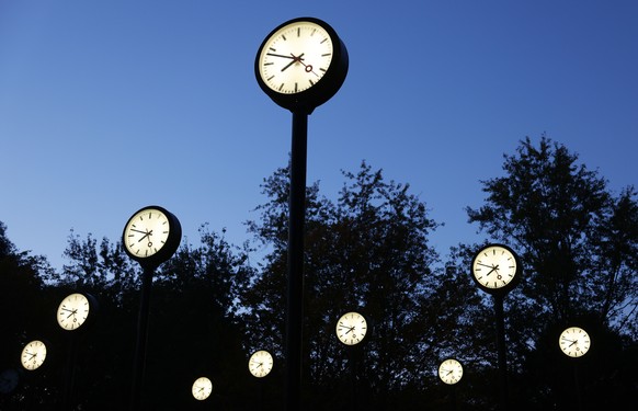 PRODUKTION - 25.10.2021, Nordrhein-Westfalen, D�sseldorf: Uhren leuchten am Morgen im Zeitfeld im Volksgarten. Die Zeitumstellung von Sommer- auf Winterzeit ist in der Nacht zum 31.10.2021. (Zu dpa: & ...
