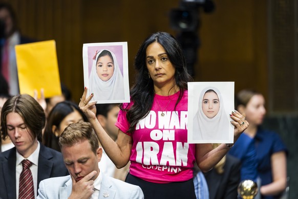 epa13125393 Protesters hold up pictures of Iranian girls before US Secretary of Defense Hegseth and Chairman of the Joint Chiefs General John testify on the Defense Department's budget before the ...