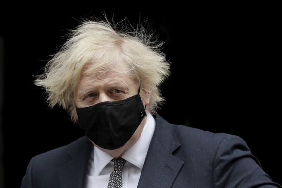 Wearing a number 10 logo face mask to curb the spread of coronavirus British Prime Minister Boris Johnson leaves 10 Downing Street in London, to attend the weekly Prime Minister&#039;s Questions at th ...