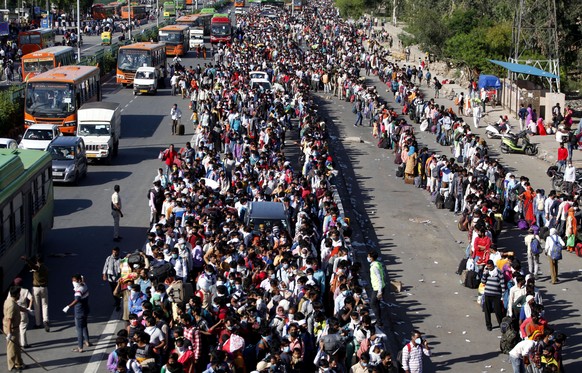 Indian migrant laborers wait for buses provided by the government to transport them to their hometowns, following a lockdown amid concern over spread of coronavirus in New Delhi, India, Saturday, Marc ...