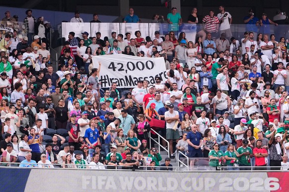 KEYPIX - Fans hold a sign reading "42,000 #IranMassacre" during the World Cup Group G soccer match between Iran and New Zealand in Inglewood, Calif., near Los Angeles, Monday, June 15, 2026. ...