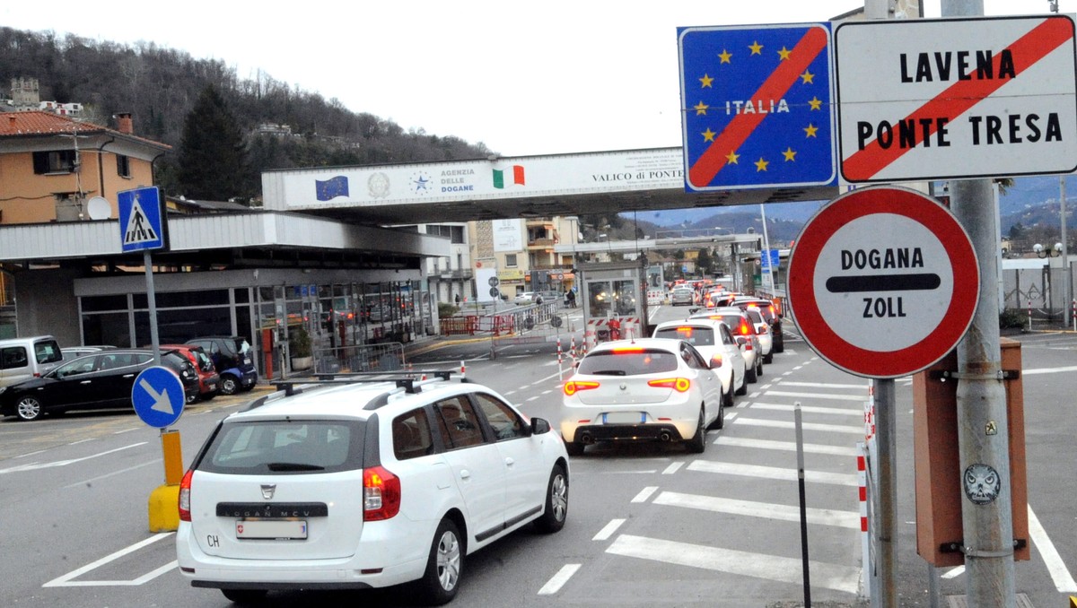epa08282914 A view of cars queuing at the Swiss-Italian border waiting for customs in Ponte Tresa, near Varese, Italy, 10 March 2020. There are no particular restrictions for those who work across bor ...