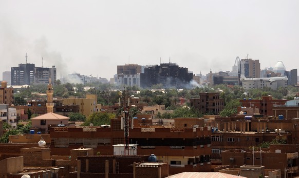 epa10578766 A civilian holds up an empty shell casing in front of a damaged window of a residential building during ongoing clashes between the Sudanese army and paramilitaries of the Rapid Support Forces...