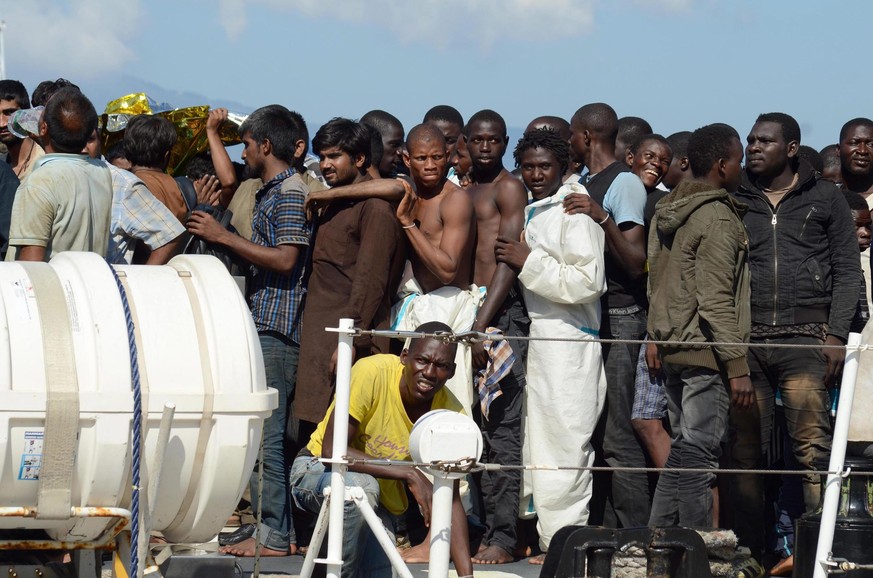 epa04902388 Some 250 migrants rescued in the Mediterranean Sea disembark from the Italian Coast Guard ship Fiorillo in the harbor of Reggio Calabria, southern Italy, 28 August 2015. The Italian Coast  ...