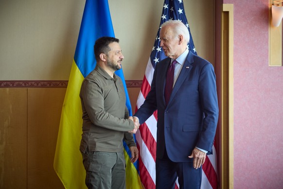 epa10642761 A handout photo made available by the Ukrainian Presidential Press Service shows Ukrainian President Volodymyr Zelensky (L) and US President Joe Biden (R) shaking hands during a meeting…