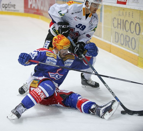 EHC Kloten Stuermer Denis Hollenstein, vorne, gegen EHC Biel Verteidiger Mike Lundin waehrend dem Eishockey-Meisterschaftsspiel der National League A zwischen dem EHC Kloten und dem EHC Biel am Freita ...