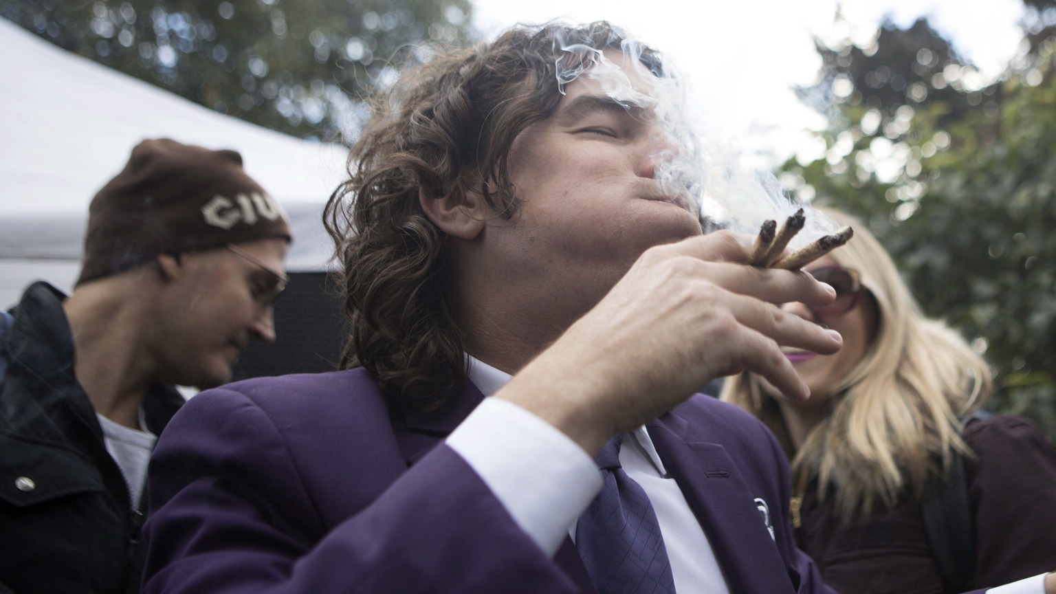 FILE - In this Oct. 17, 2018, file photo, a man smokes multiple joints in a Toronto park as they mark the first day of legalization of cannabis across Canada. Supply shortages have been rampant in the ...