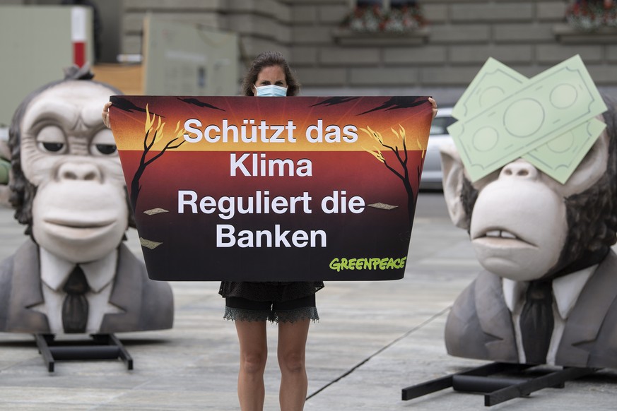 Aktivisten von Greenpeace Schweiz demonstrieren mit uebergrossen Affenkoepfen gegen die Finanzindustrie, am Mittwoch, 15. Juli 2020, in Bern. Greenpeace macht diese wegen der Finanzierung von Brennsto ...