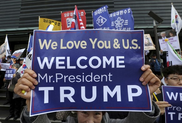 A South Korean protesters against North Korea holds up a card during a rally welcoming the visit by U.S. President Donald Trump near the U.S. Embassy in Seoul, South Korea, Monday, Nov. 6, 2017. Trump ...