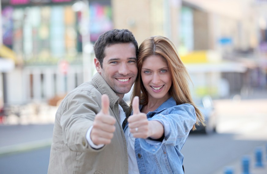 Happy couple thumbs up. Stock photo