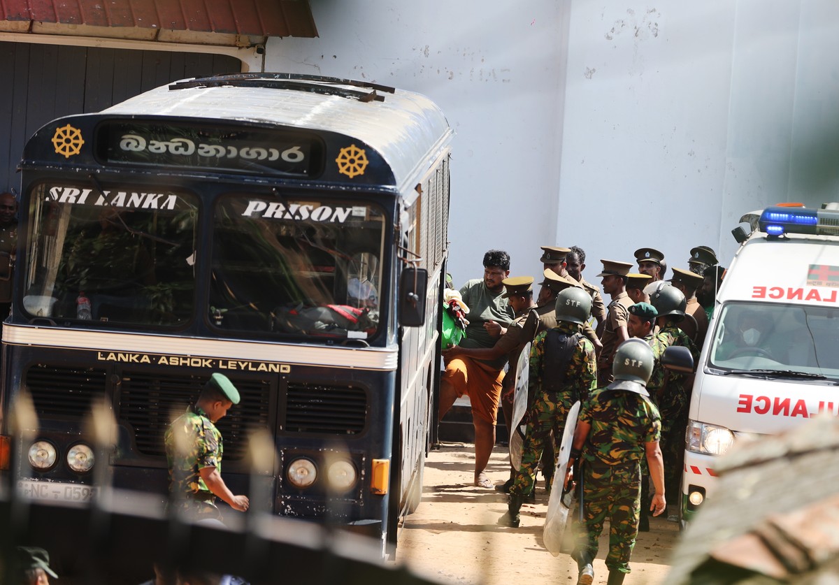 epa13091569 Security personnel escort prisoners to a bus at Negombo Prison on the outskirts of Colombo, Sri Lanka, 06 July 2026. Clashes at the prison have killed 25 people, including four prison guar ...