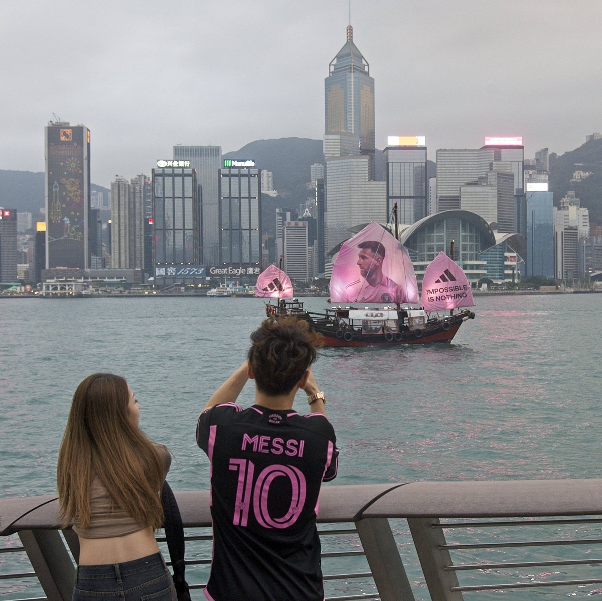 HONG KONG, CHINA - FEBRUARY 03: Fans take photos as a sailing ship bearing a portrait of Inter Miami CF s Argentine forward Lionel Messi sails across the Victoria Harbour on February 3, 2024 in Hong K ...