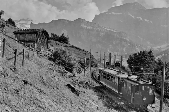 Ein Triebwagen der Engelbergbahn (StEB) mit einer Schublok HGe 2/2 auf der Steilrampe, aufgenommen im Jahr 1910.
https://commons.wikimedia.org/wiki/File:CH-NB_Photoglob-Wehrli_EAD-WEHR-12043-B.tif