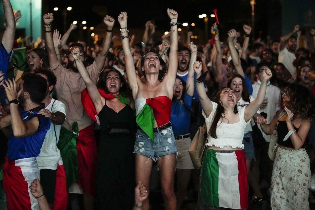 Fans react as Italy's Federico Chiesa scored his side's first goal as they watch on a giant screen the Euro 2020 soccer semifinal match between Italy and Spain, in Rome, Tuesday, July 6, 202 ...