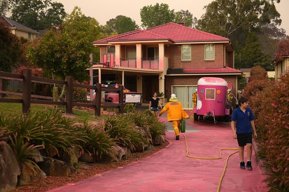 epa07990082 Chemical fire retardant sits on houses after being dropped by aircraft in South Turramurra, near Sydney, New South Wales, Australia, 12 November 2019. At least 60 fires are burning across  ...