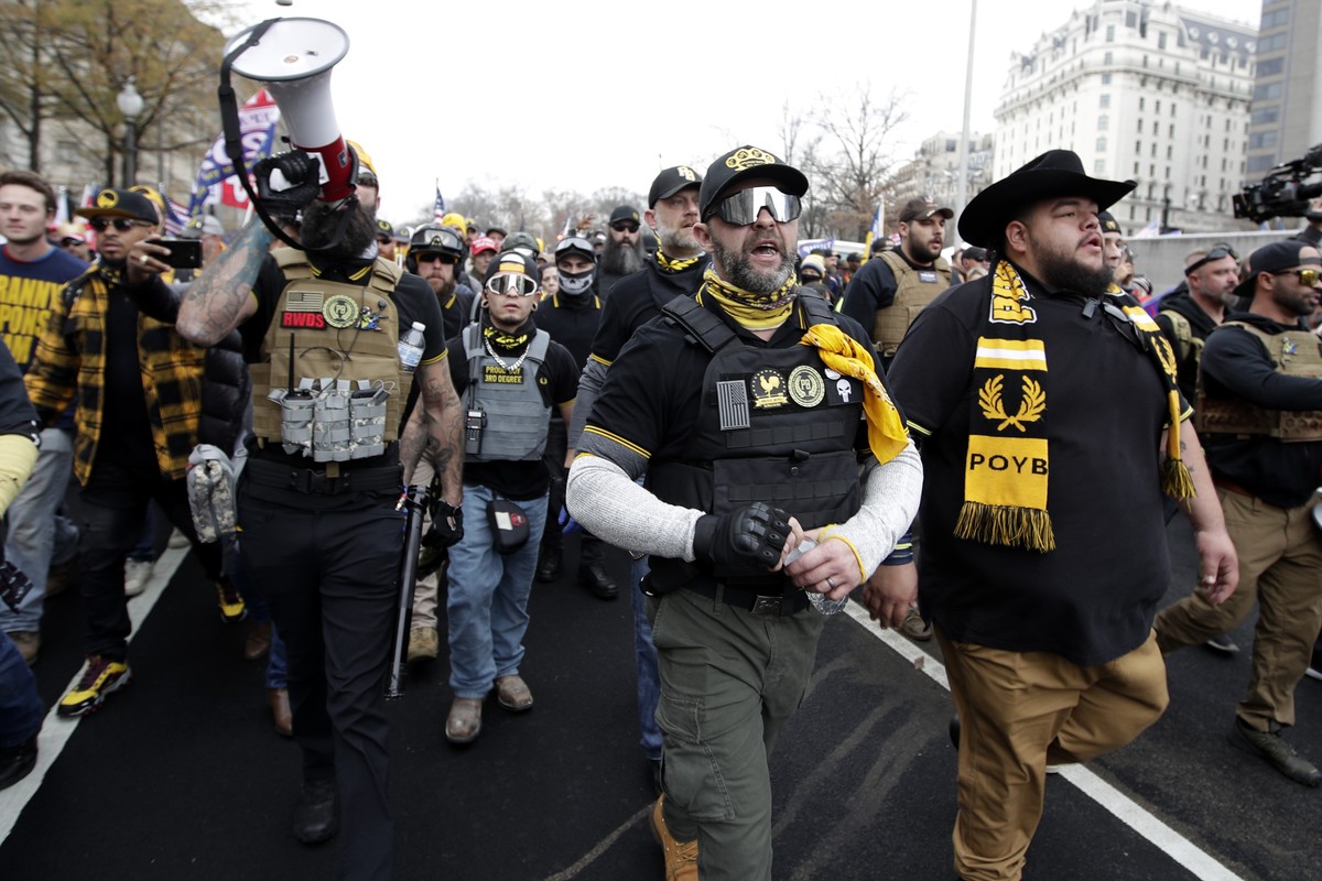 Supporters of President Donald Trump who are wearing attire associated with the Proud Boys attend a rally at Freedom Plaza, Saturday, Dec. 12, 2020, in Washington. (AP Photo/Luis M. Alvarez)