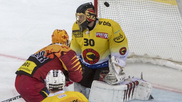 Tigers Harry Pesonen, links, erzielt das 3:1, gegen Berns Goalie Leonardo Genoni, rechts, waehrend dem Meisterschaftsspiel der National League, zwischen den SCL Tigers und dem SC Bern am Samstag 13.Ok ...