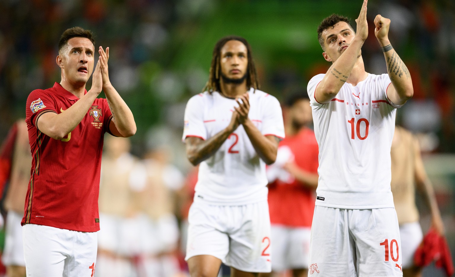 Swiss players (L-R) Mario Gavranovic, Kevin Mbabu, and Granit Xhaka applaud fans after losing the UEFA Nations League group A2 soccer match between Portugal and Switzerland at the Estadio Jose Alvalad ...