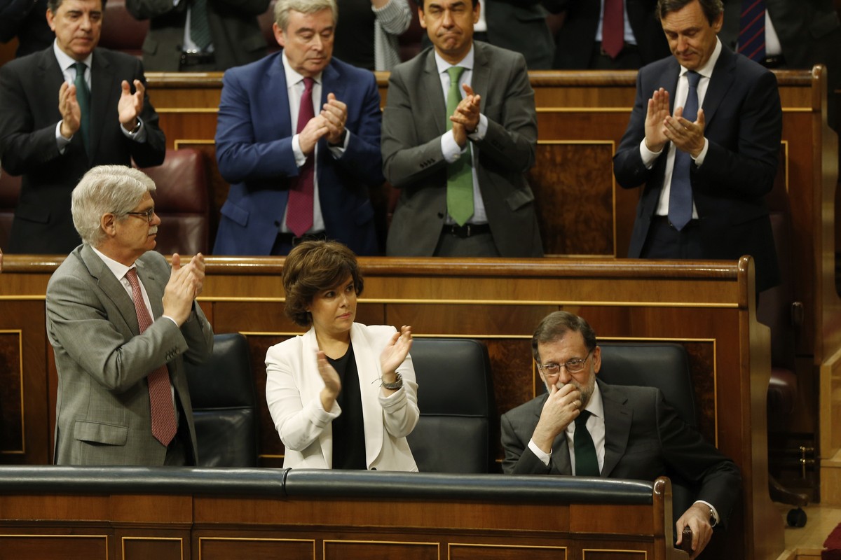 Spain's Prime Minister Mariano Rajoy, bottom right is applauded by members of his party during the second day of a motion of no confidence session at the Spanish parliament in Madrid, Friday, Jun ...