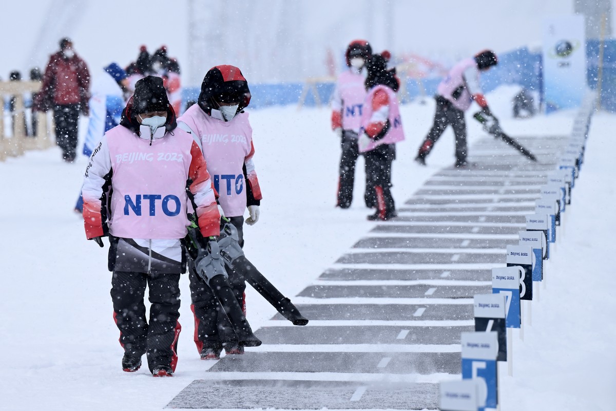 epa09751686 Steff cleans the shooting range from snow prior the Women's Biathlon 10km Pursuit race at the Zhangjiakou National Biathlon Centre at the Beijing 2022 Olympic Games, Zhangjiakou, Chin ...