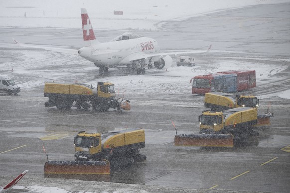 Fahrzeuge befreien den Flughafen von den verschneiten Pisten, aufgenommen am Samstag, 2. Dezember 2023 auf dem Flughafen in Zuerich. (KEYSTONE/Ennio Leanza)