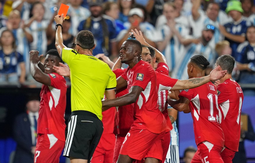 Referee Joao Pinheiro, of Portugal, gives a red card to Switzerland's Breel Embolo (7), left, during the World Cup quarterfinal soccer match between Argentina and Switzerland in Kansas City, Mo., ...