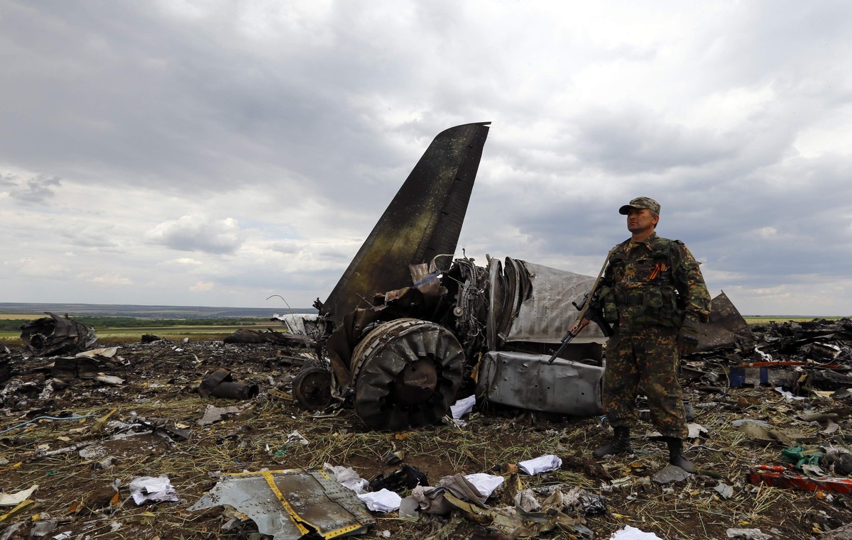 Ein prorussischer Separatist vor dem Wrack des abgeschossenen Flugzeugs.