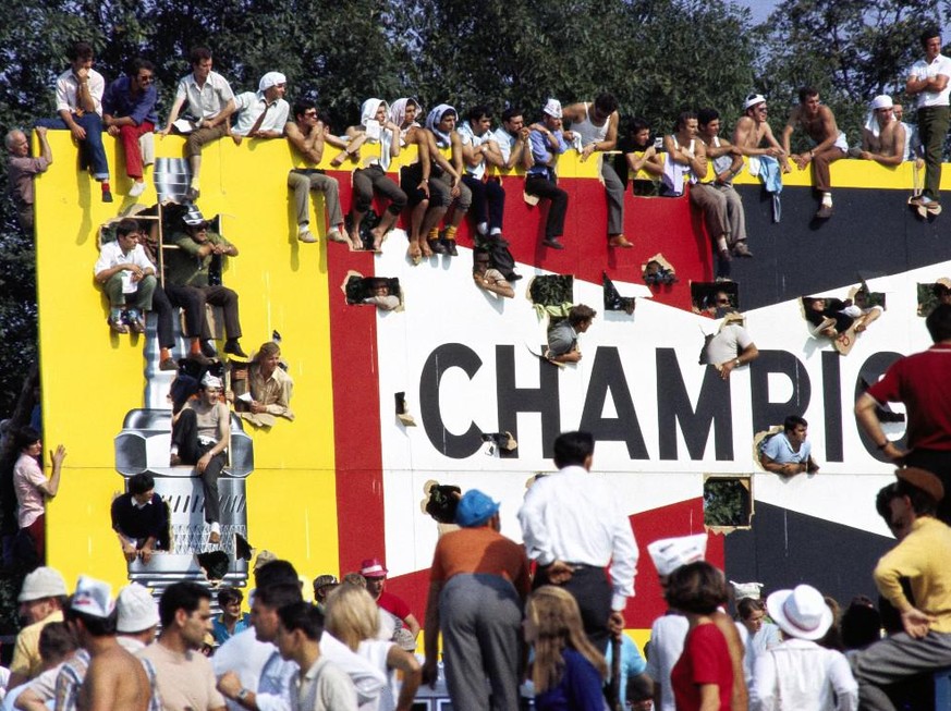 1968 Italian GP AUTODROMO NAZIONALE MONZA, ITALY - SEPTEMBER 08: Tifosi climb onto and through an advertising billboard for a better vantage point during the Italian GP at Autodromo Nazionale Monza on ...