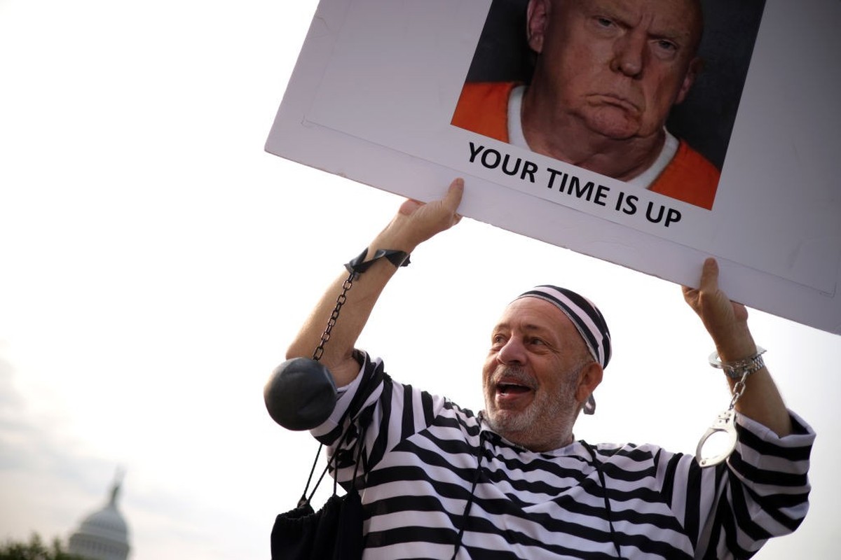 WASHINGTON, DC - AUGUST 03: Protester Domenic Santana of Miami, Florida, holds a sign outside the E. Barrett Prettyman United States Courthouse August 3, 2023 in Washington, DC. Former U.S. President  ...