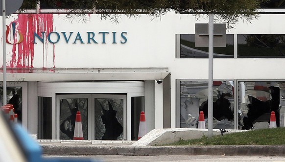 epa06564265 Stains of red paint and smashed windows are seen at the entrance of the headquarters of Swiss pharmaceutical company Novartis Hellas following an attack by Greek anarchist group &#039;Rouv ...