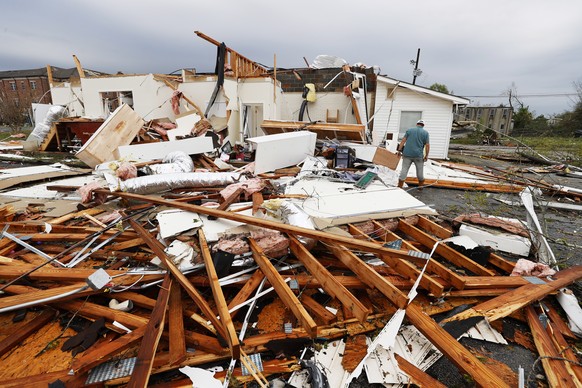 epa09099373 Tommy Sweet sifts through debris from a building he owns after an apparent tornado swept through Newnan, Georgia USA, 26 March 2021. The spring severe weather outbreak left at least six pe ...