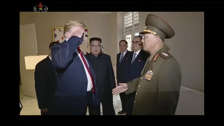 In this image made from June 12, 2018, video released by KRT, U.S. President Donald Trump salutes No Kwang Chol, minister of the People&#039;s Armed Forces of North Korea, as North Korean leader Kim J ...