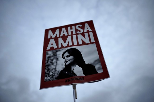 FILE - A woman holds a sign with a photo of Iranian woman Mahsa Amini during a protest against her death, in Berlin, Germany, Wednesday, September 28, 2022. Mahsa Amini, the 22-year-old Kurdish-Iranian...