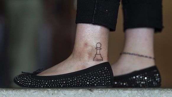 epaselect epa06920445 A woman has a pawn tattooed on her ankle as she attends the 51st Biel International Chess Festival, in the Congress Center in Biel, Switzerland, 31 July 2018. The chess festival  ...