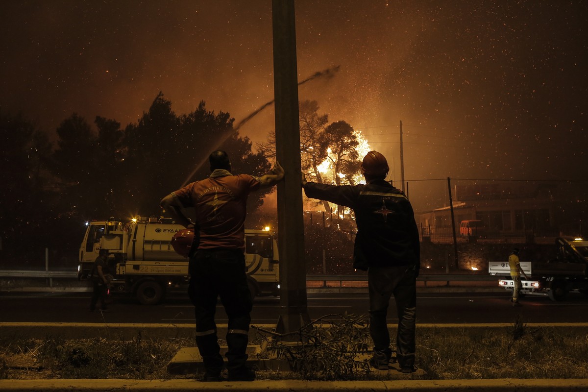 epaselect epa09399552 Volunteer firefighters look at the flames approaching a main highway in the area of Afidnes near Athens, Greece, 05 August 2021 (issued 06 August 2021). Firefighters are relying  ...